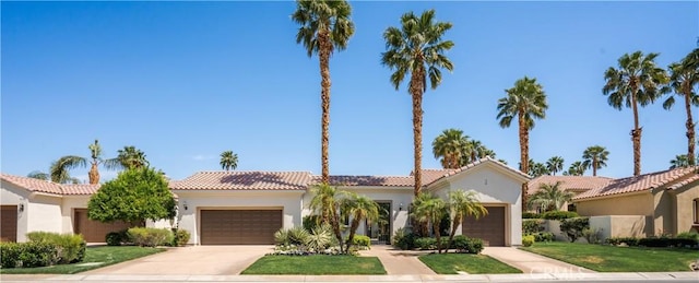 56610 Muirfield Ln, Quinta, CA 92253 - mediterranean / spanish-style house with an attached garage, a tile roof, concrete driveway, and stucco siding