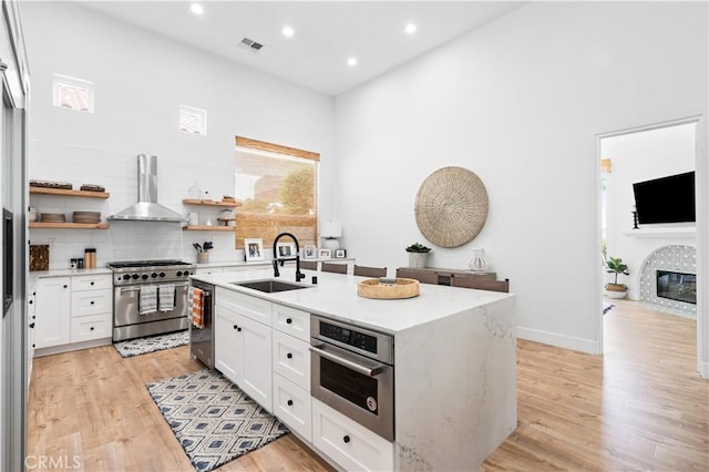 56610 Muirfield Ln, Quinta, CA 92253 - kitchen featuring appliances with stainless steel finishes, wall chimney range hood, open shelves, white cabinetry, and recessed lighting