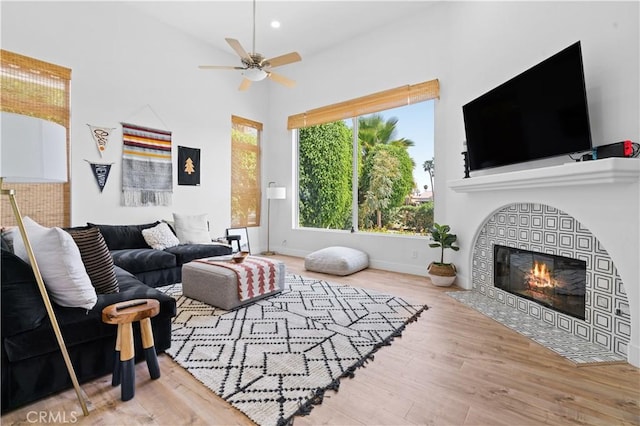 56610 Muirfield Ln, Quinta, CA 92253 - living room featuring wood finished floors, ceiling fan, a high ceiling, and a tiled fireplace