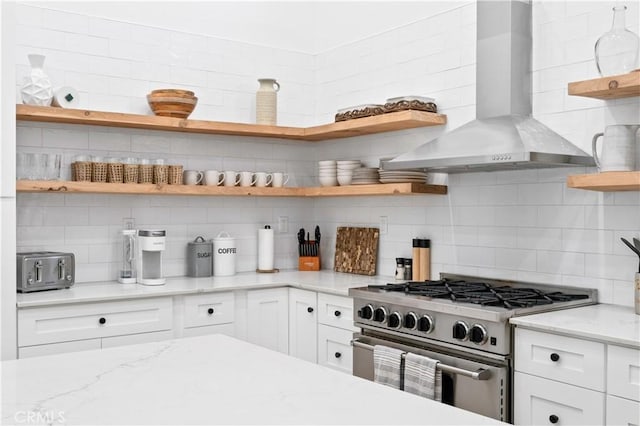 56610 Muirfield Ln, Quinta, CA 92253 - kitchen featuring open shelves, wall chimney exhaust hood, high end stainless steel range oven, backsplash, and white cabinetry