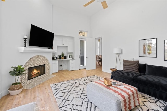 56610 Muirfield Ln, Quinta, CA 92253 - living room featuring ceiling fan, high vaulted ceiling, light wood finished floors, and a fireplace with flush hearth