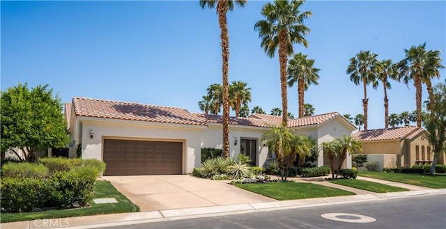 56610 Muirfield Ln, Quinta, CA 92253 - mediterranean / spanish home with a tiled roof, an attached garage, stucco siding, and driveway