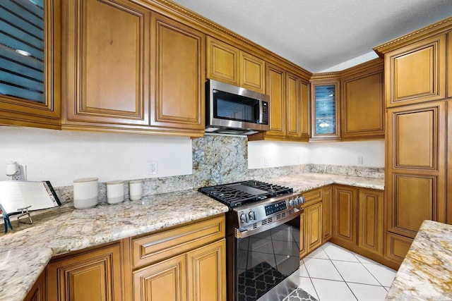 18103 Smokesignal Dr, San Diego, CA 92127 - kitchen with appliances with stainless steel finishes, brown cabinets, light tile patterned floors, and glass insert cabinets