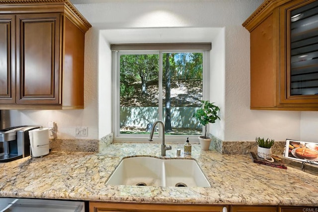 18103 Smokesignal Dr, San Diego, CA 92127 - kitchen with light stone countertops, glass insert cabinets, a textured wall, brown cabinets, and dishwasher