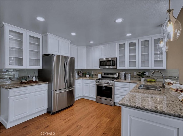22182 Platino, Mission Viejo, CA 92691 - kitchen featuring appliances with stainless steel finishes, white cabinetry, backsplash, light stone counters, and recessed lighting