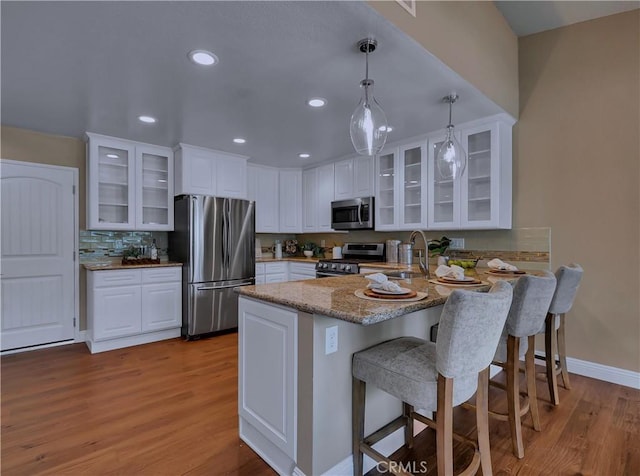 22182 Platino, Mission Viejo, CA 92691 - kitchen featuring stainless steel appliances, a peninsula, wood finished floors, white cabinetry, and recessed lighting