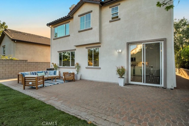 24186 Matthew Pl, Newhall, CA 91321 - back of house at dusk featuring an outdoor living space, a patio area, and stucco siding