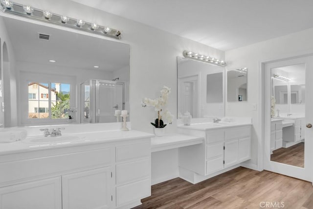 24186 Matthew Pl, Newhall, CA 91321 - bathroom featuring two vanities, a shower stall, and wood finished floors