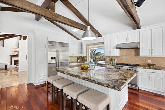 10255 Overhill Dr, Santa Ana, CA 92705 - kitchen featuring premium appliances, under cabinet range hood, dark wood-style flooring, white cabinetry, and decorative backsplash