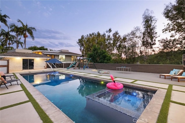 10255 Overhill Dr, Santa Ana, CA 92705 - pool at dusk with a playground, a patio area, and a pool with connected hot tub