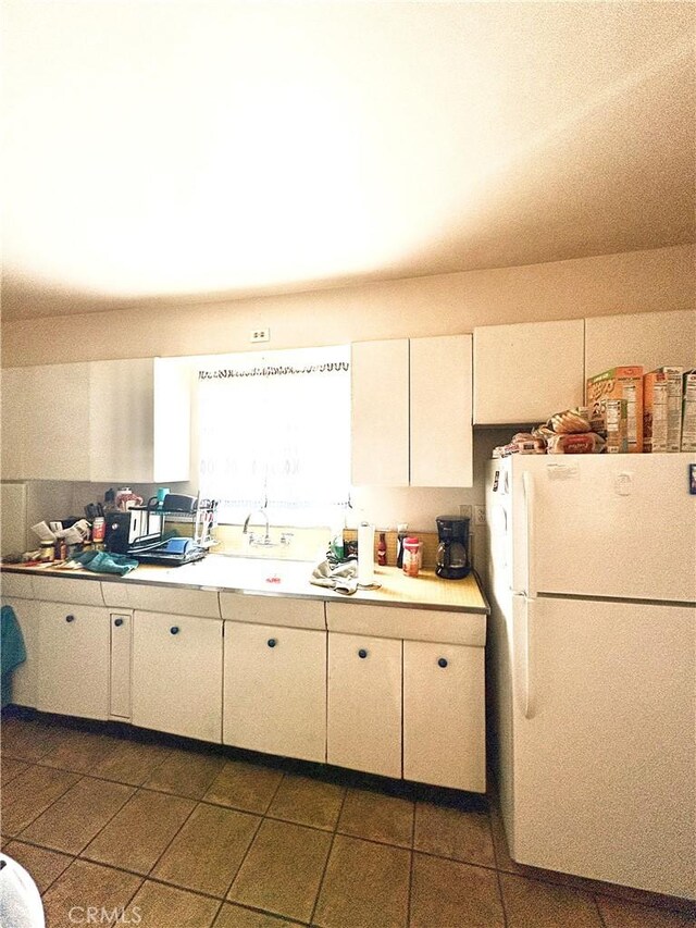 927 E Murphy, Blythe, CA 92225 - kitchen featuring freestanding refrigerator, light countertops, tile patterned floors, and white cabinetry