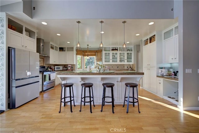 2166 Lopez Dr, Arroyo Grande, CA 93420 - kitchen with appliances with stainless steel finishes, wall chimney exhaust hood, decorative backsplash, white cabinetry, and light wood-style floors