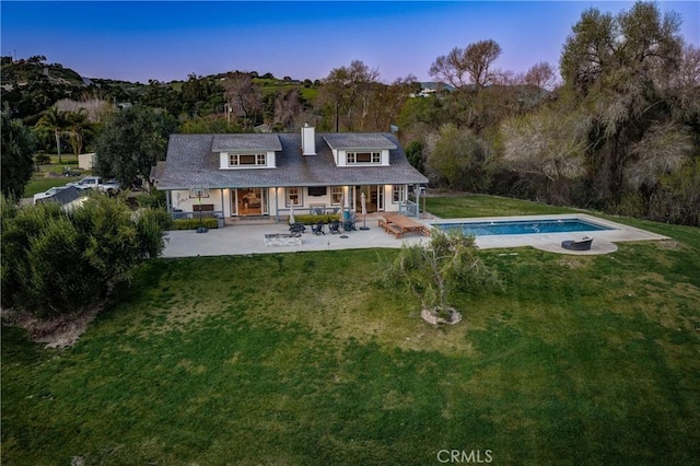 2166 Lopez Dr, Arroyo Grande, CA 93420 - back of house at dusk with an outdoor pool, a yard, a porch, and a chimney