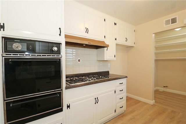1116 N Center St, Orange, CA 92867 - kitchen with a warming drawer, oven, dark countertops, under cabinet range hood, and white cabinetry