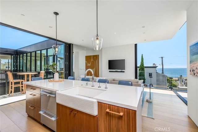 2821 Alma Ave, Manhattan Beach, CA 90266 - kitchen with a wall of windows, open floor plan, brown cabinetry, light wood-type flooring, and light countertops