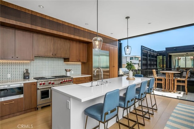 2821 Alma Ave, Manhattan Beach, CA 90266 - kitchen with high quality appliances, tasteful backsplash, light countertops, a breakfast bar area, and pendant lighting