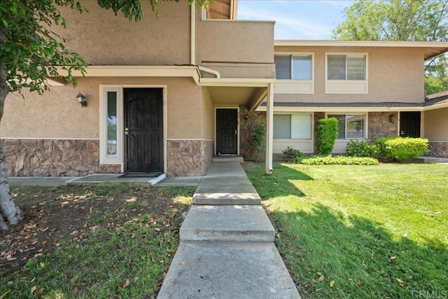 955 Amistad Pl Unit C, El Cajon, CA 92019 - view of front of house featuring stucco siding, a front yard, and stone siding