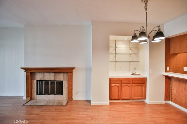 11600 Warner Ave Unit 428, Fountain Valley, CA 92708 - kitchen featuring light wood-style flooring, brown cabinetry, and a tile fireplace