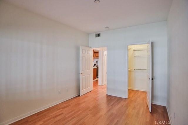 11600 Warner Ave Unit 428, Fountain Valley, CA 92708 - unfurnished bedroom featuring light wood-style floors, a walk in closet, and a closet