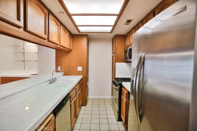 11600 Warner Ave Unit 428, Fountain Valley, CA 92708 - kitchen with stainless steel appliances, tile countertops, and brown cabinets