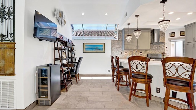 24965 Seagate, Dana Point, CA 92629 - kitchen with wall chimney exhaust hood, beverage cooler, stainless steel electric range, gray cabinetry, and decorative backsplash