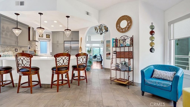 24965 Seagate, Dana Point, CA 92629 - kitchen featuring stainless steel fridge, gray cabinetry, a kitchen bar, backsplash, and a peninsula