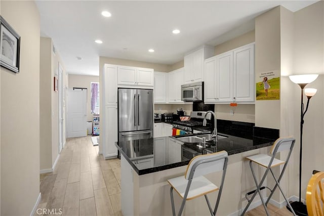 1152 Newberry Ln, Claremont, CA 91711 - kitchen with stainless steel appliances, a peninsula, white cabinetry, a breakfast bar, and recessed lighting