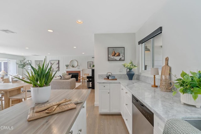 455 E Laurel Ave, Sierra Madre, CA 91024 - kitchen with dishwasher, a fireplace, white cabinetry, light wood-style flooring, and light stone counters