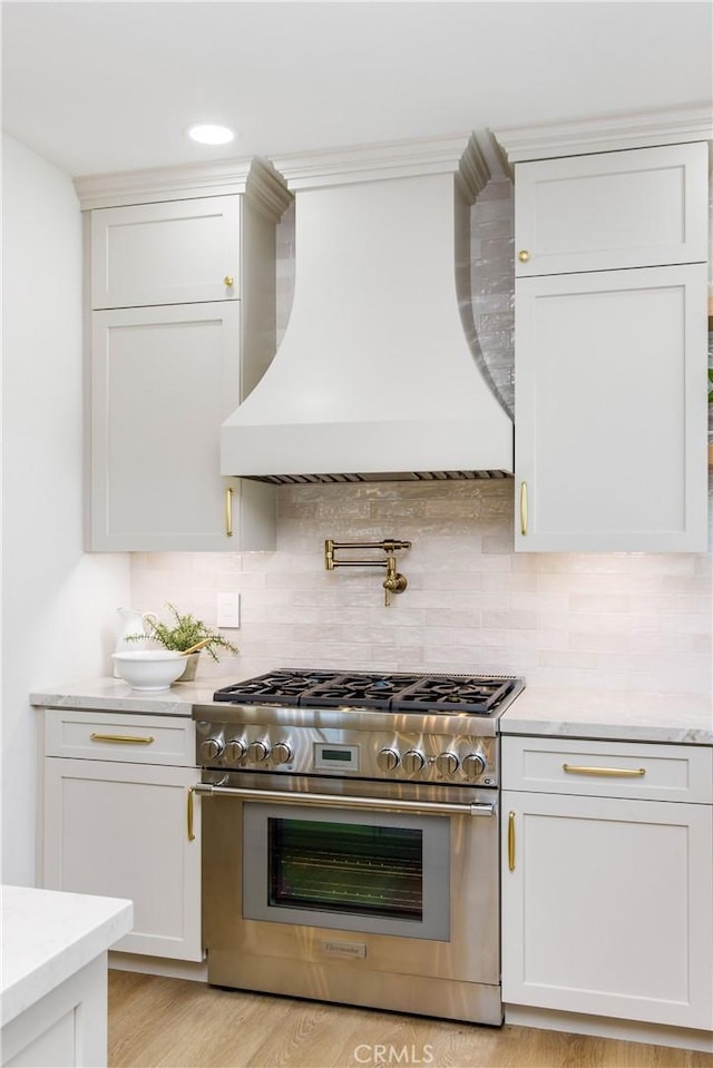 245 Surf Pl, Seal Beach, CA 90740 - kitchen featuring high end stove, custom range hood, decorative backsplash, white cabinetry, and recessed lighting