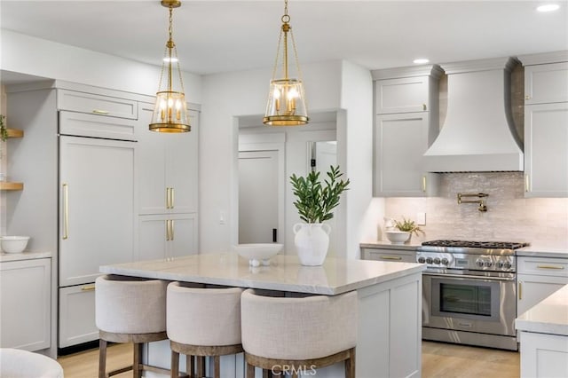 245 Surf Pl, Seal Beach, CA 90740 - kitchen with custom range hood, high end stainless steel range oven, tasteful backsplash, light wood-style flooring, and recessed lighting