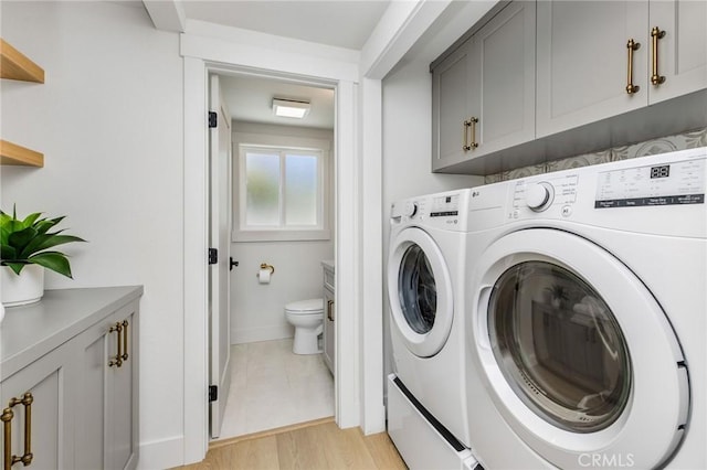 245 Surf Pl, Seal Beach, CA 90740 - laundry area with washer and dryer, cabinet space, and light wood-style floors