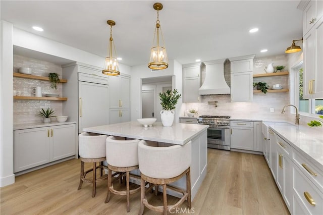 245 Surf Pl, Seal Beach, CA 90740 - kitchen featuring high end stainless steel range oven, custom exhaust hood, open shelves, tasteful backsplash, and a center island