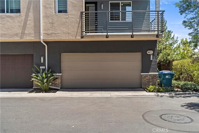 253 Steely, Irvine, CA 92614 - view of front of home with stucco siding, a balcony, and a garage