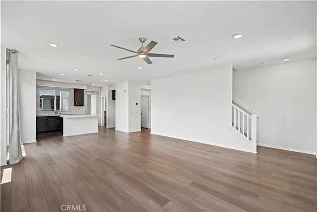 253 Steely, Irvine, CA 92614 - unfurnished living room with wood finished floors, a ceiling fan, recessed lighting, and stairway