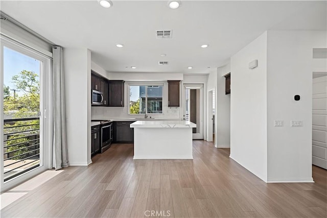 253 Steely, Irvine, CA 92614 - kitchen featuring appliances with stainless steel finishes, light countertops, light wood-type flooring, dark brown cabinets, and recessed lighting