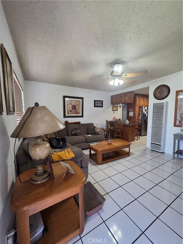 12157 Nava St, Norwalk, CA 90650 - living room with a heating unit, ceiling fan, a textured ceiling, and light tile patterned floors