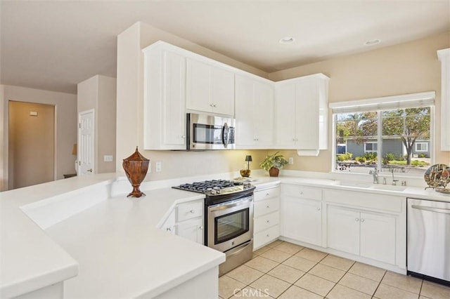 1432 Blackberry Ave, Arroyo Grande, CA 93420 - kitchen featuring appliances with stainless steel finishes, a peninsula, light tile patterned floors, light countertops, and white cabinetry