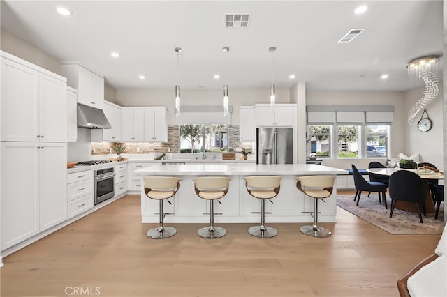 133 Denali, Lake Forest, CA 92630 - kitchen with stainless steel appliances, extractor fan, a center island, light countertops, and tasteful backsplash