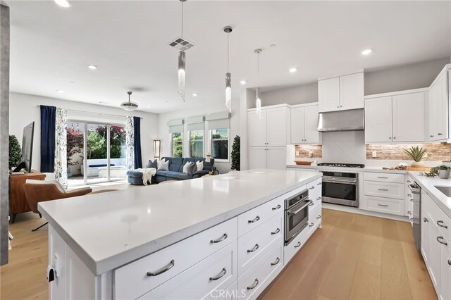 133 Denali, Lake Forest, CA 92630 - kitchen with appliances with stainless steel finishes, under cabinet range hood, light wood-style flooring, a kitchen island, and open floor plan