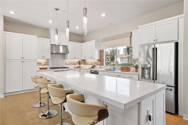 133 Denali, Lake Forest, CA 92630 - kitchen featuring high quality fridge, under cabinet range hood, a kitchen island, decorative backsplash, and white cabinets