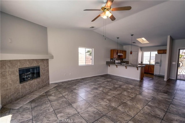 9464 Palm Dr, Desert Hot Springs, CA 92240 - unfurnished living room featuring lofted ceiling, ceiling fan, and a tile fireplace