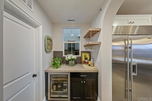 15614 S Chevy Chase, San Diego, CA 92127 - indoor dry bar featuring stainless steel built in fridge, wine cooler, tasteful backsplash, and arched walkways
