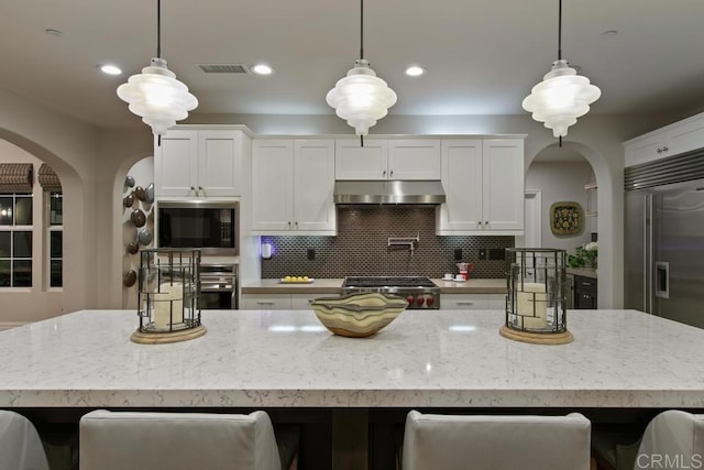 15614 S Chevy Chase, San Diego, CA 92127 - kitchen with arched walkways, built in appliances, under cabinet range hood, white cabinetry, and a breakfast bar area