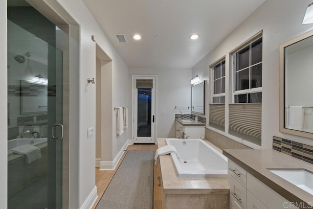 15614 S Chevy Chase, San Diego, CA 92127 - bathroom featuring two vanities, a shower stall, a garden tub, wood finished floors, and recessed lighting