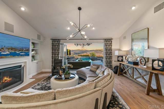 15614 S Chevy Chase, San Diego, CA 92127 - living room with vaulted ceiling, a chandelier, wood finished floors, built in shelves, and a glass covered fireplace