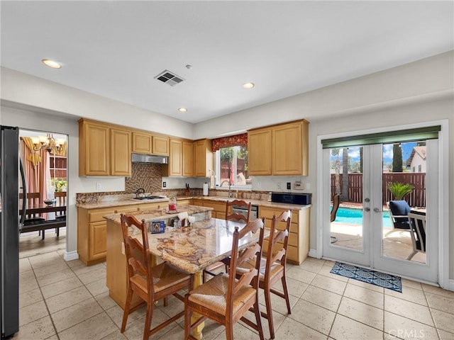 13906 Lexicon Ave, Sylmar, CA 91342 - kitchen with freestanding refrigerator, under cabinet range hood, french doors, a chandelier, and stainless steel dishwasher