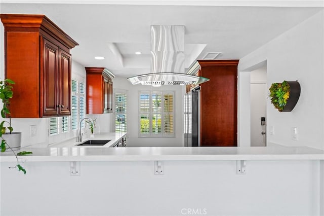 710 S Tourmaline Ct, Anaheim Hills, CA 92807 - kitchen with dark brown cabinets, light countertops, a tray ceiling, refrigerator, and island range hood