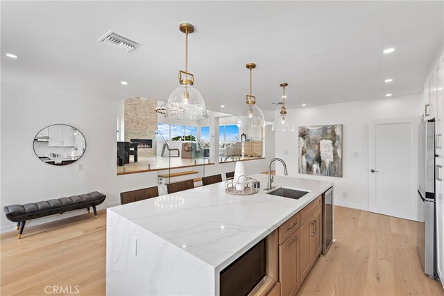 8 Clipper Rd, Rancho Palos Verdes, CA 90275 - kitchen with light wood finished floors, recessed lighting, a center island with sink, hanging light fixtures, and built in microwave
