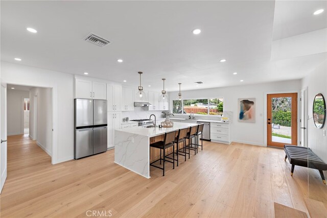 8 Clipper Rd, Rancho Palos Verdes, CA 90275 - kitchen featuring stainless steel appliances, light wood-type flooring, recessed lighting, white cabinetry, and a breakfast bar