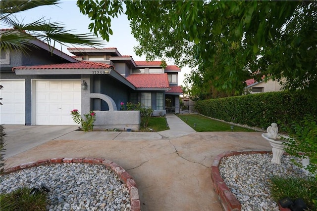 37908 52nd St E, Palmdale, CA 93552 - view of front of home featuring concrete driveway, a tile roof, an attached garage, and stucco siding